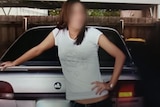 A girl, Alyssa, whose face is blurred, leans on a car in a relaxed way.