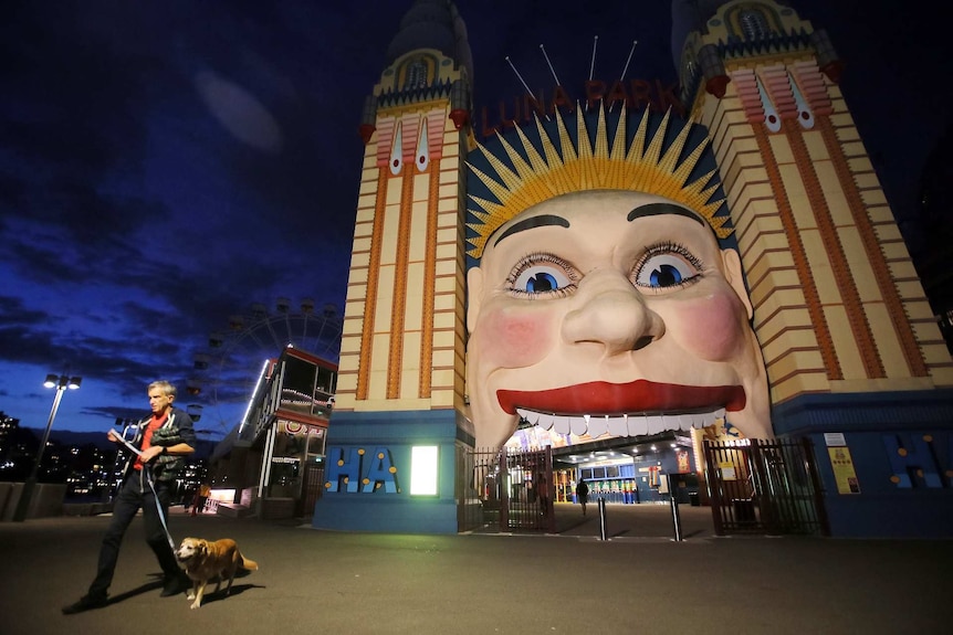 a man walking his dog outside a theme park