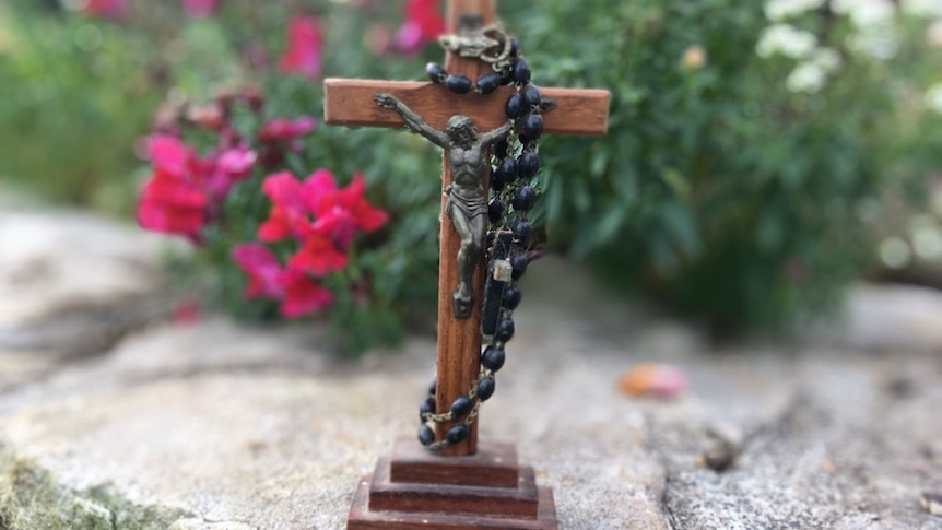 A crucifix in front of flowers