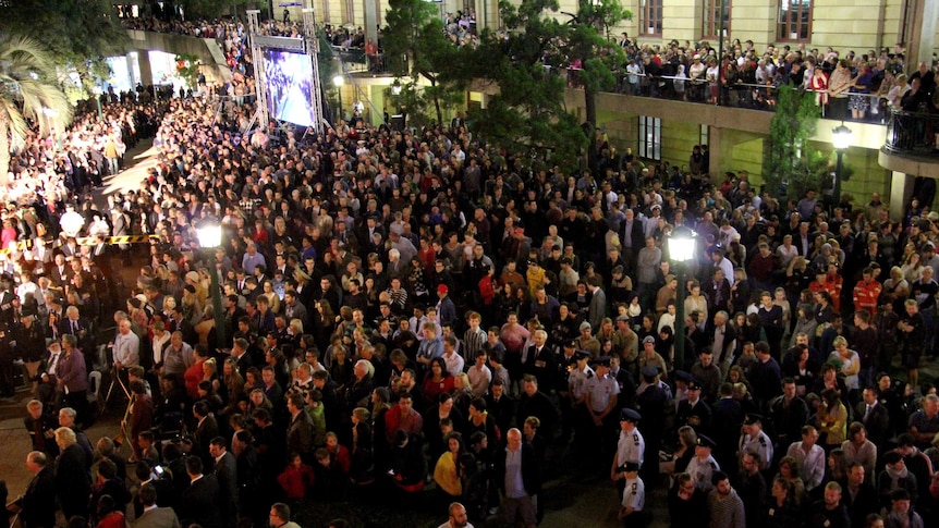 Part of the crowd look on at the Brisbane Anzac Day dawn service.