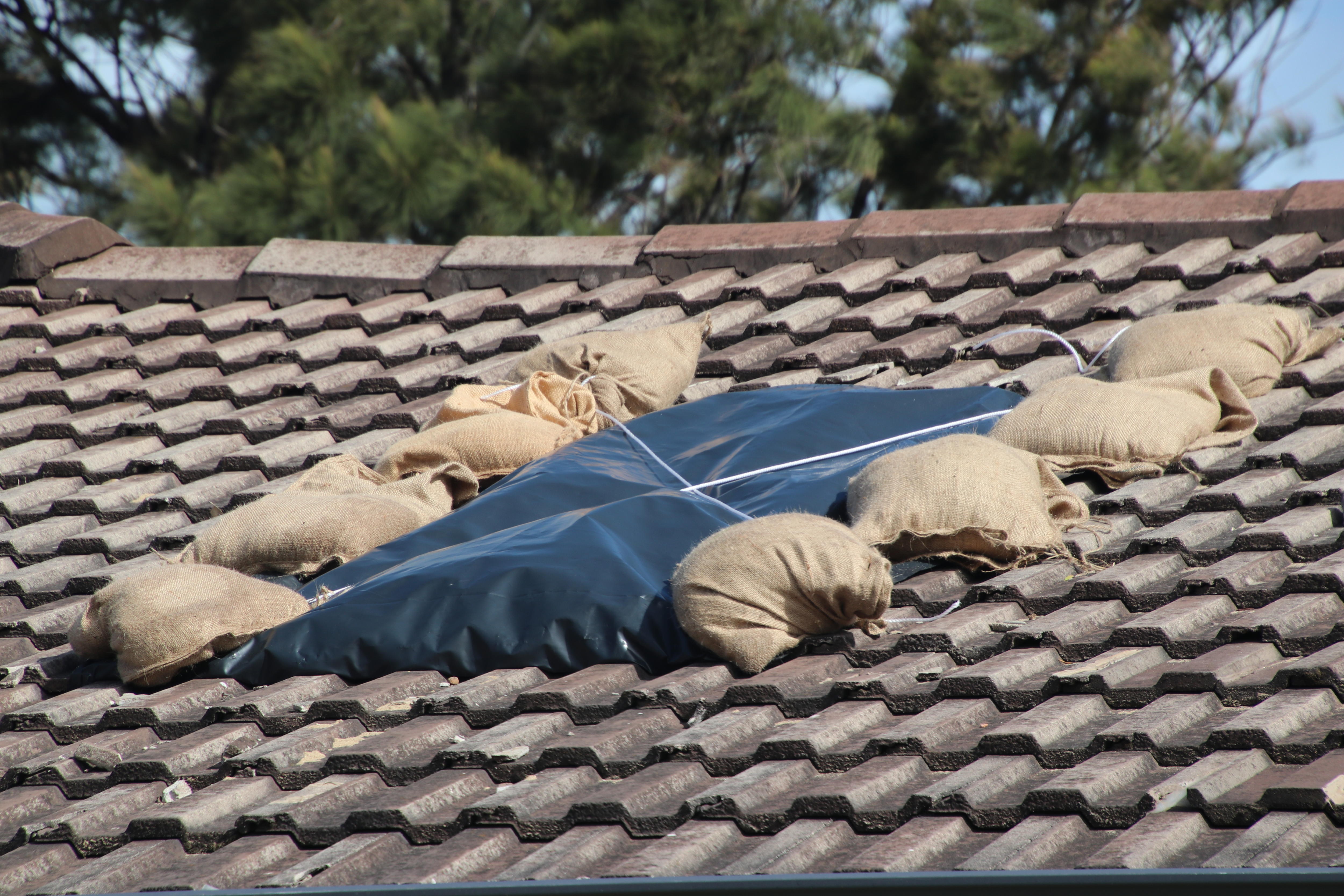 Sandbags and plastic placed over a damaged roof