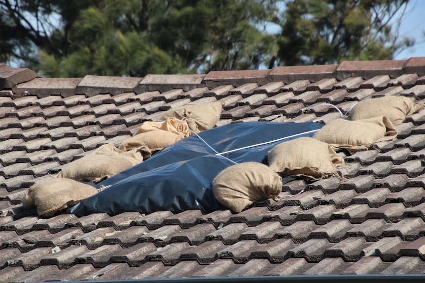 Sandbags and plastic placed over a damaged roof