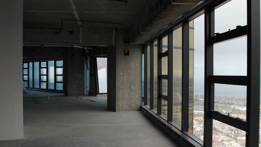 Inside an empty concrete high-rise apartment with no furnishings.