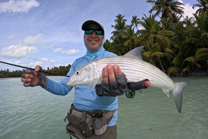 A man holds a fish