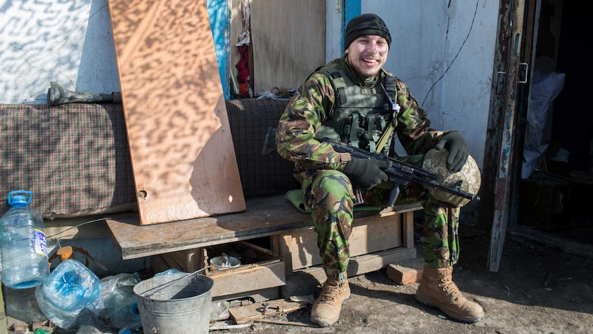 A Ukrainian soldier enjoys a moment in the sun between rounds of gunfire.