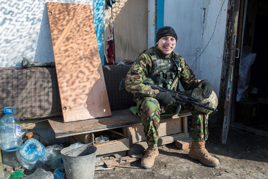 A Ukrainian soldier enjoys a moment in the sun between rounds of gunfire.