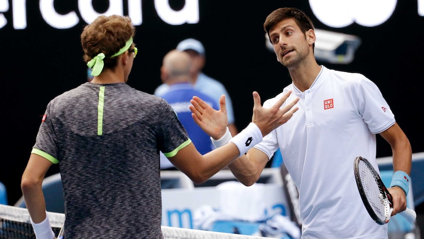 Serbia's Novak Djokovic (R) congratulates Uzbekistan's Denis Istomin after Australian Open match.