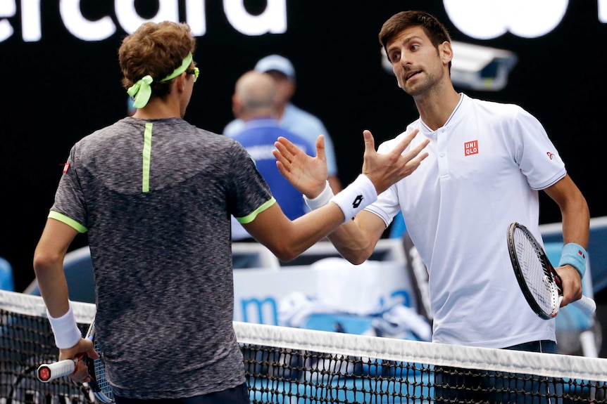 Serbia's Novak Djokovic (R) congratulates Uzbekistan's Denis Istomin after Australian Open match.
