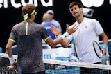 Serbia's Novak Djokovic (R) congratulates Uzbekistan's Denis Istomin after Australian Open match.