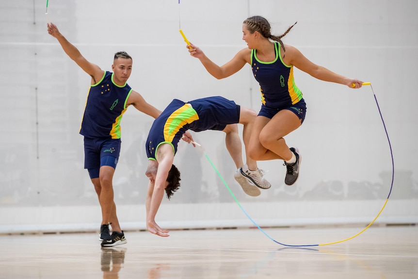 Lilly Barker and two teammates jump in the air while holding skipping ropes.