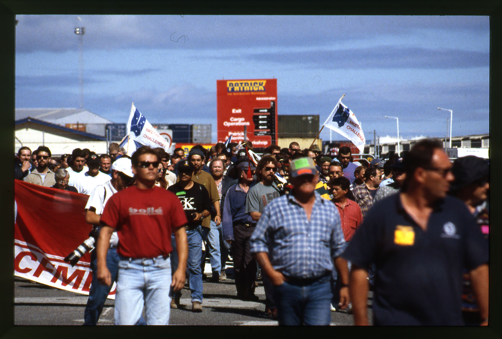 A group of mostly male protestors walking outside the Patricks Stevedore docks 