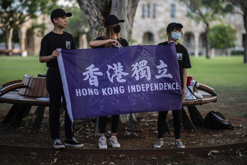 Max Mok and two others hold a banner reading 'Hong Kong independence'.