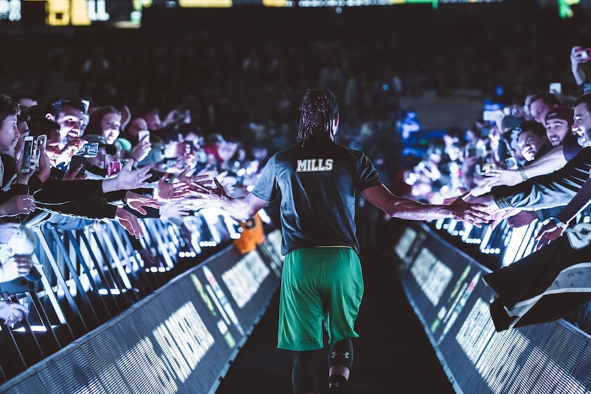 Basketball star walking onto court amidst fan