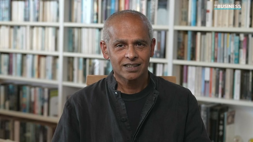 Das sits in front of a wall of books