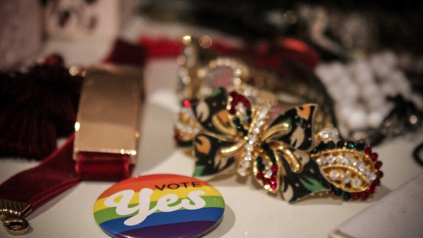 A 'Yes' badge sits in between Emily Wells' jewellery.