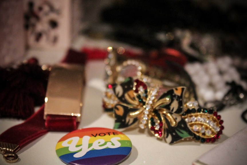 A 'Yes' badge sits in between Emily Wells' jewellery.