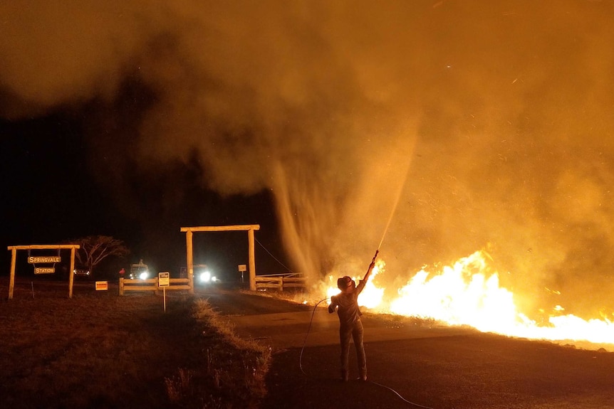 Stacey Marriot fights a fire with a hose on the nearby State Government owned Springvale Station.