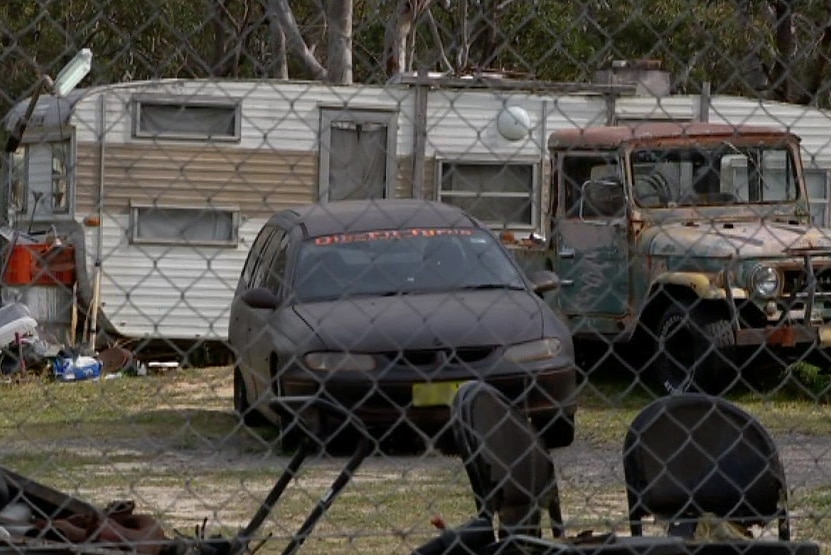 Two cars parked next to a caravan