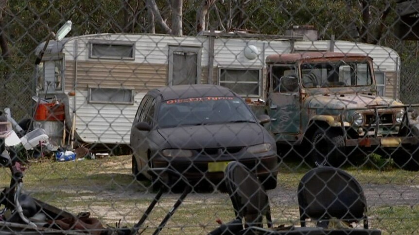 Two cars parked next to a caravan