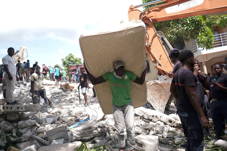 Haiti man carries mattress