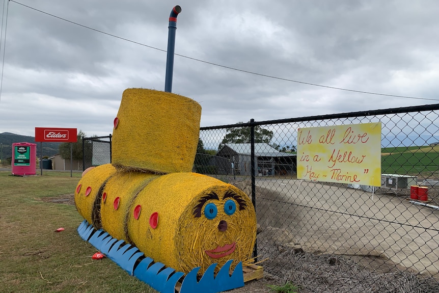 Haybales presented as a yellow submarine with the sign 'We all live in a yellow hay-marine'