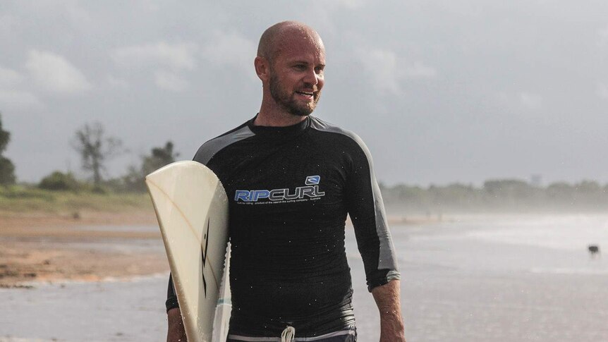 a male surfer looking at the swell