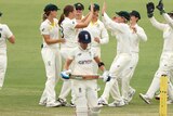 The Australians celebrate as Lauren Winfield-Hall walks away from the crease