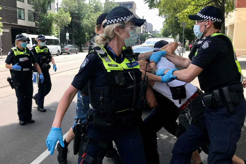 A group of police grapple with an unidentifiable protester.