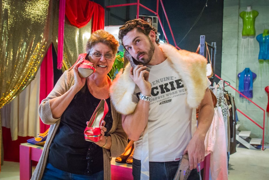 Helen Logan and charity director Michael Stafford hold clothes up at their store.