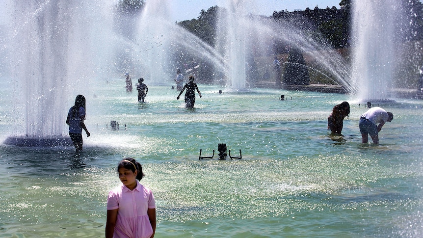 Children and adults play in the fountains of the Trocadero gardens in Paris.