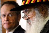 Tight photo of heads - Bill Shorten, out of focus, listens to Pat Dodson speak.