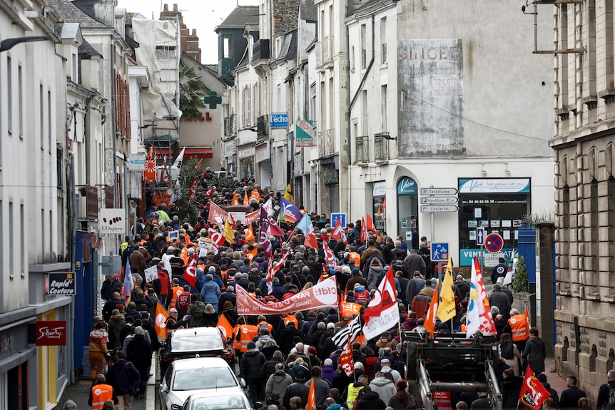 People fill the road walking with banners.