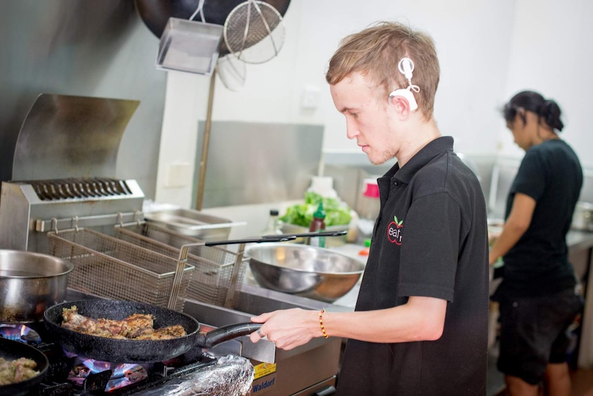 Matthew Corbett preparing meals in a cafe kitchen.