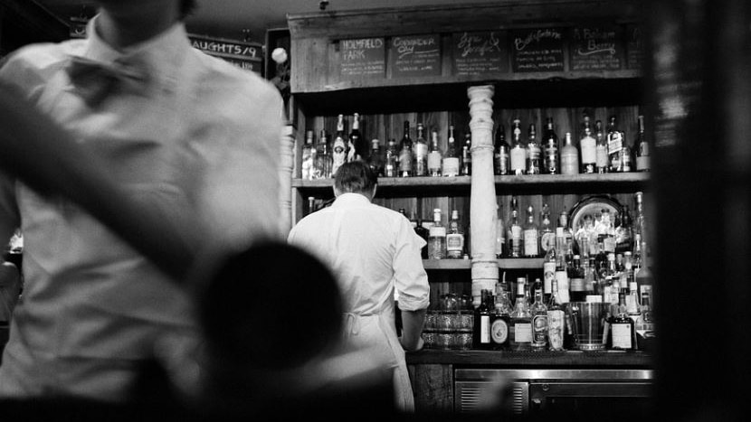 Black and white picture of people working in a bar 