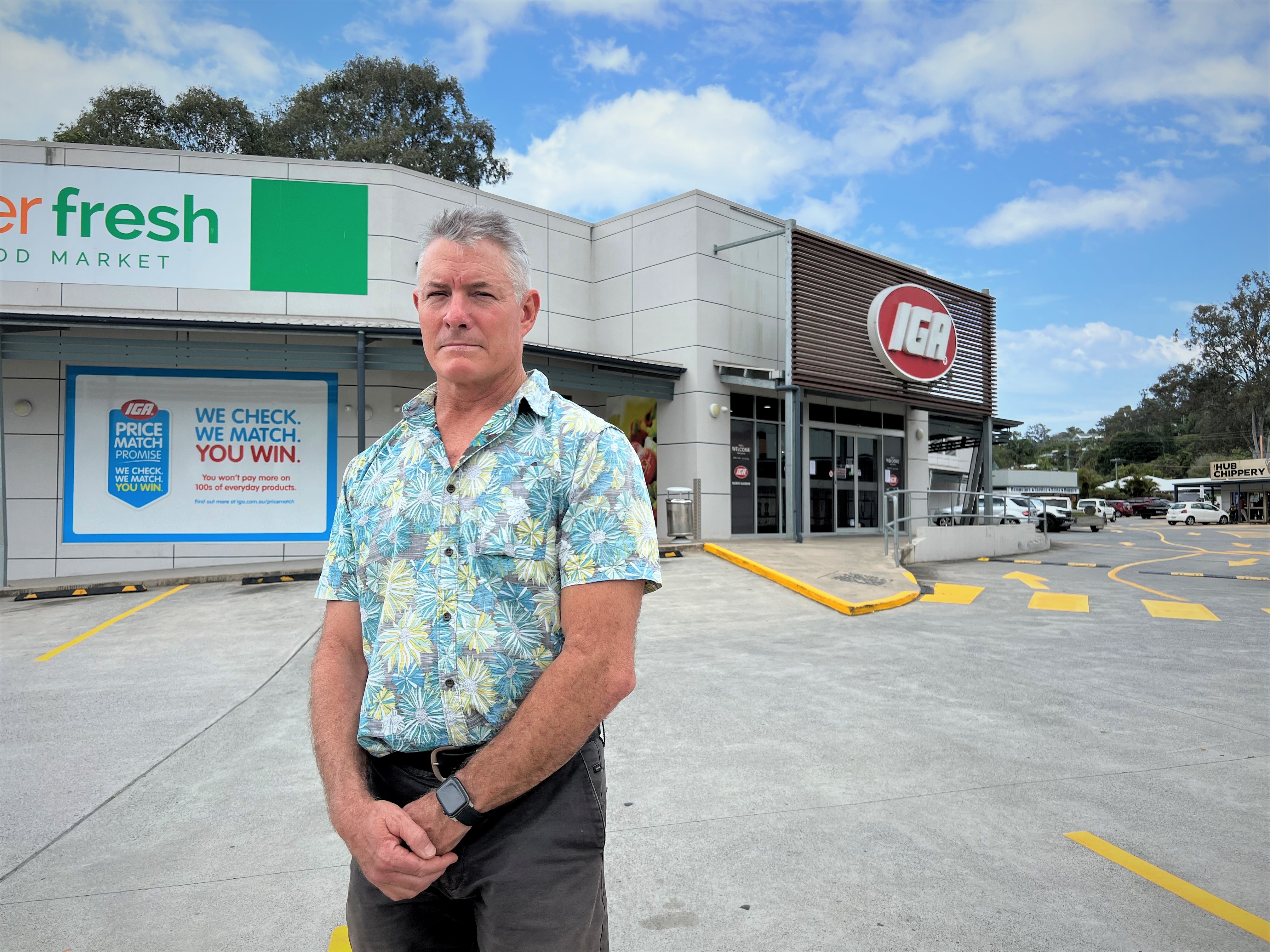 Man standing out the front of IGA supermarket