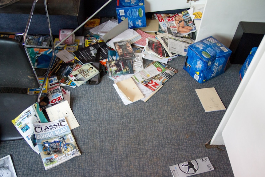 Carpeted floor covered in spilled DVDs and magazines.