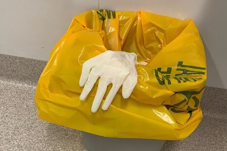 A pair of medical gloves in a hospital bin
