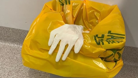 A pair of medical gloves in a hospital bin