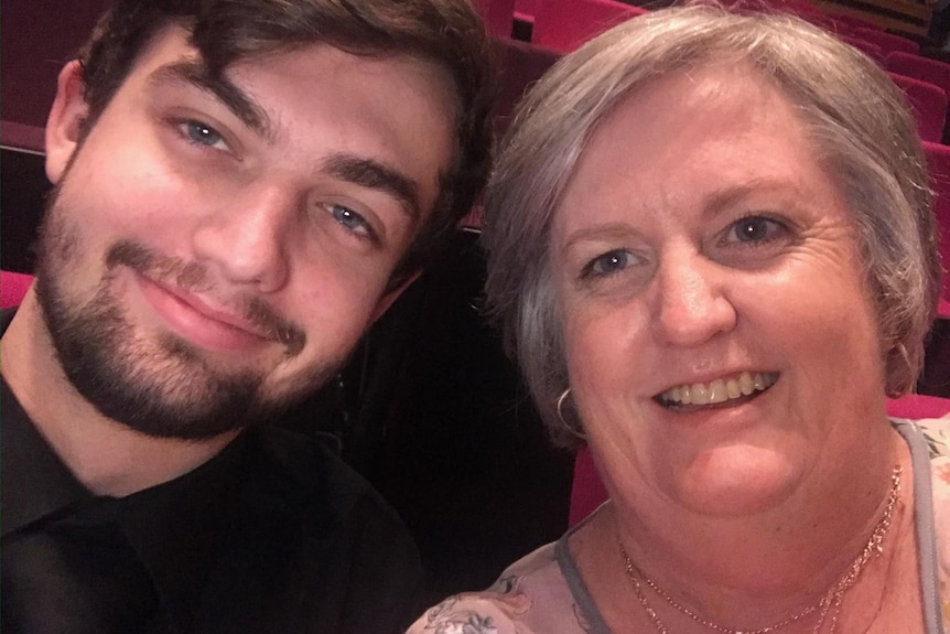 A picture of a young man and his mother together smiling 