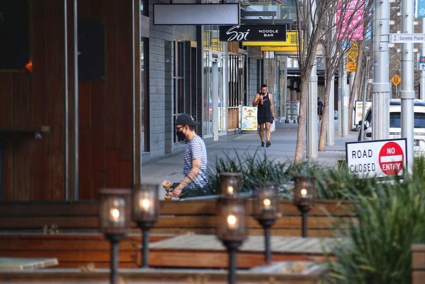 Two men in face masks on the street in Canberra.