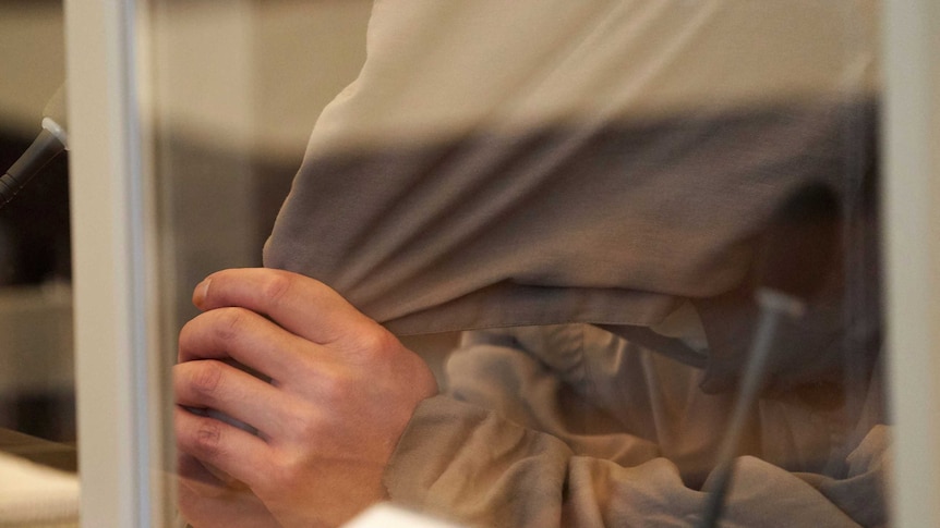 A close up of a man's head, covered by a beige cloth.