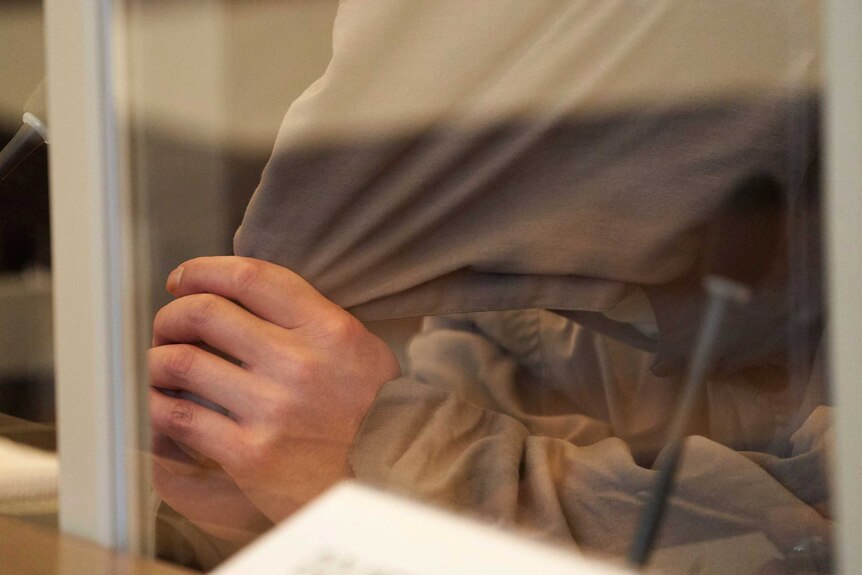 A close up of a man's head, covered by a beige cloth.