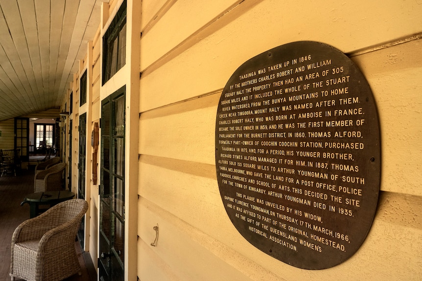 A plaque with words explaining the homestead history on a wall outside the house.