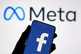 A smartphone with Facebook's logo is seen in front of displayed Facebook's new rebrand logo Meta in this illustration