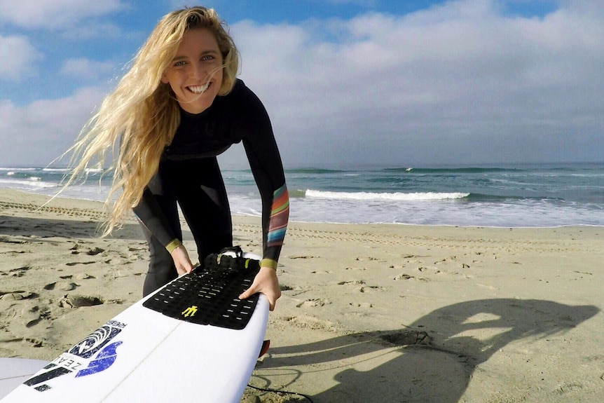 Brittani Nicholl with surfboard on beach