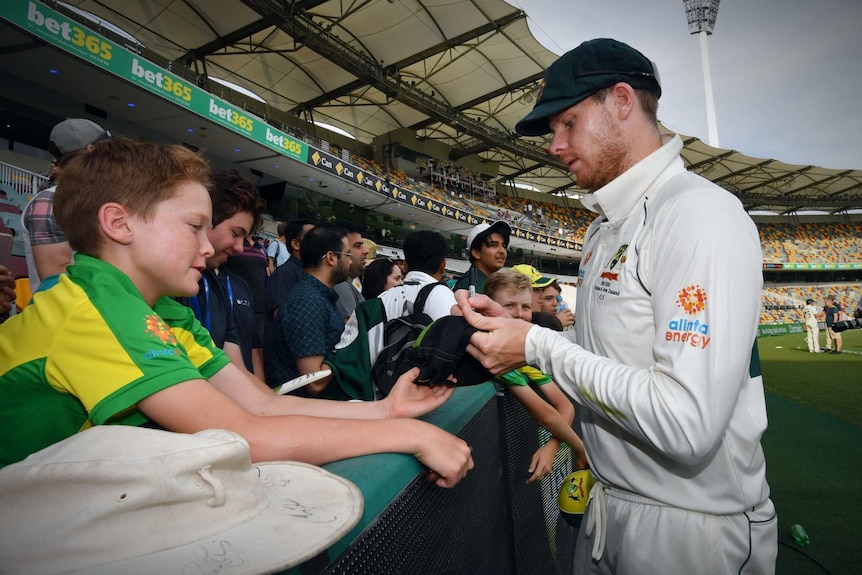 Steve Smith signing an autograph with bet365 signage in the background.