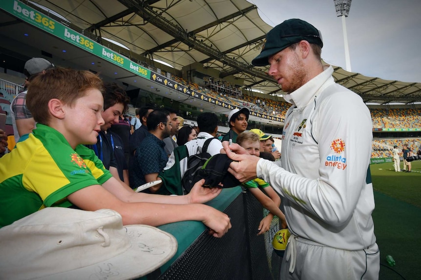 Steve Smith firmando un autógrafo con carteles de bet365 de fondo.