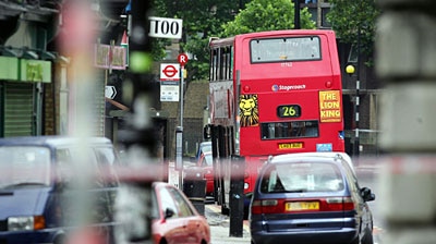A London double-decker bus is stopped on Hackney Road, after an explosion