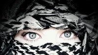 A woman's face covered with a kuffiyeh.