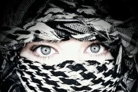 A woman's face covered with a kuffiyeh.